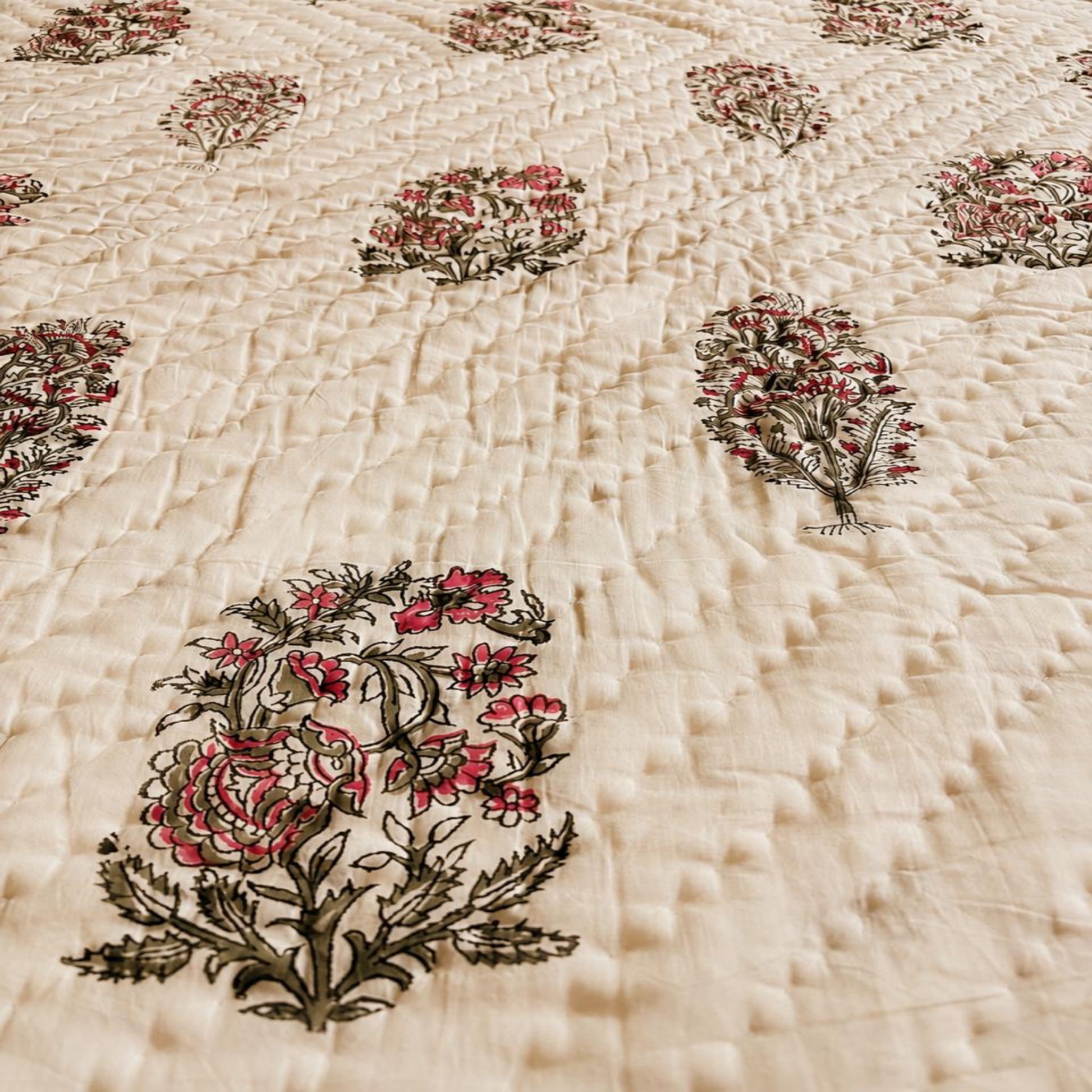 Close-up of a block print Jaipuri razai with repeating floral motifs.