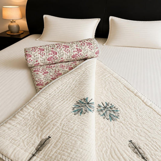 A styled bedroom scene showing beautiful floral motifs, a matching patterned pillow, and white ribbed pillows against a dark headboard.